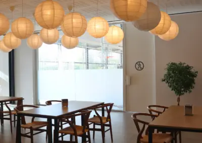 Entrada cafeteria A Prop Edifici Centre Esplai amb les taules i cadires de fons